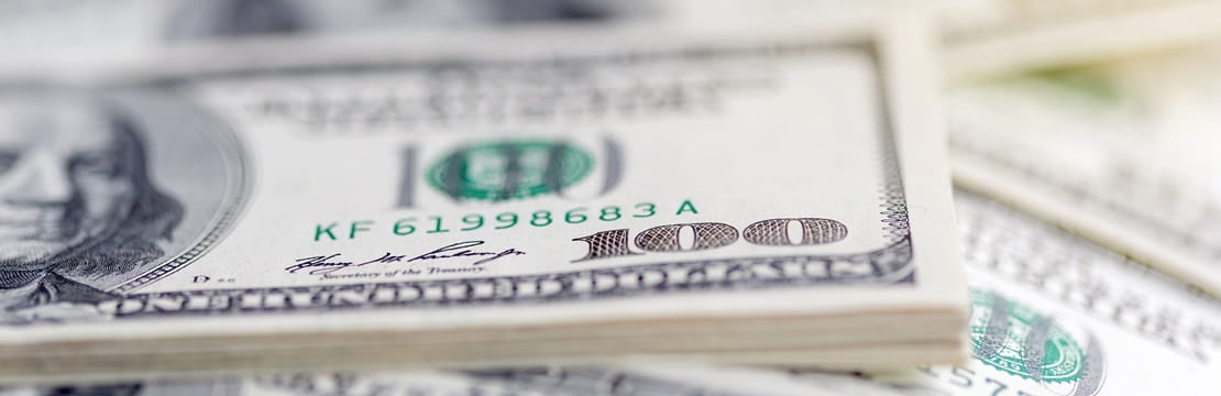Close-up view of a stack of 100 dollar bills.